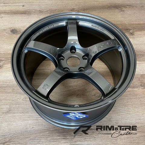 RAYS Gram Lights 57CR five-spoke alloy wheel in a sleek dark grey metallic finish with 'Made in Japan' engraving, presented on a light wooden floor