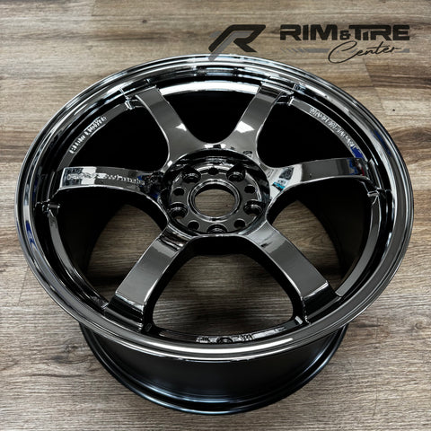 Metal RAYS wheels car rim on a wooden floor featuring a highly polished chrome finish, six V-shaped spokes, and "MADE IN JAPAN" engraving