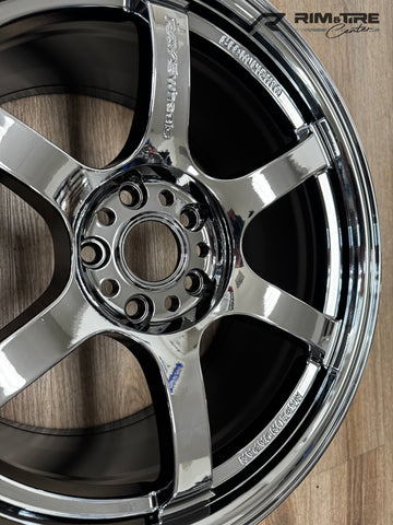 A photograph by RIM&Tire Center displays a gleaming RAYS Wheels five-spoke chrome car wheel with "MADE IN JAPAN" embossed text on the rim, positioned on a light brown wooden floor