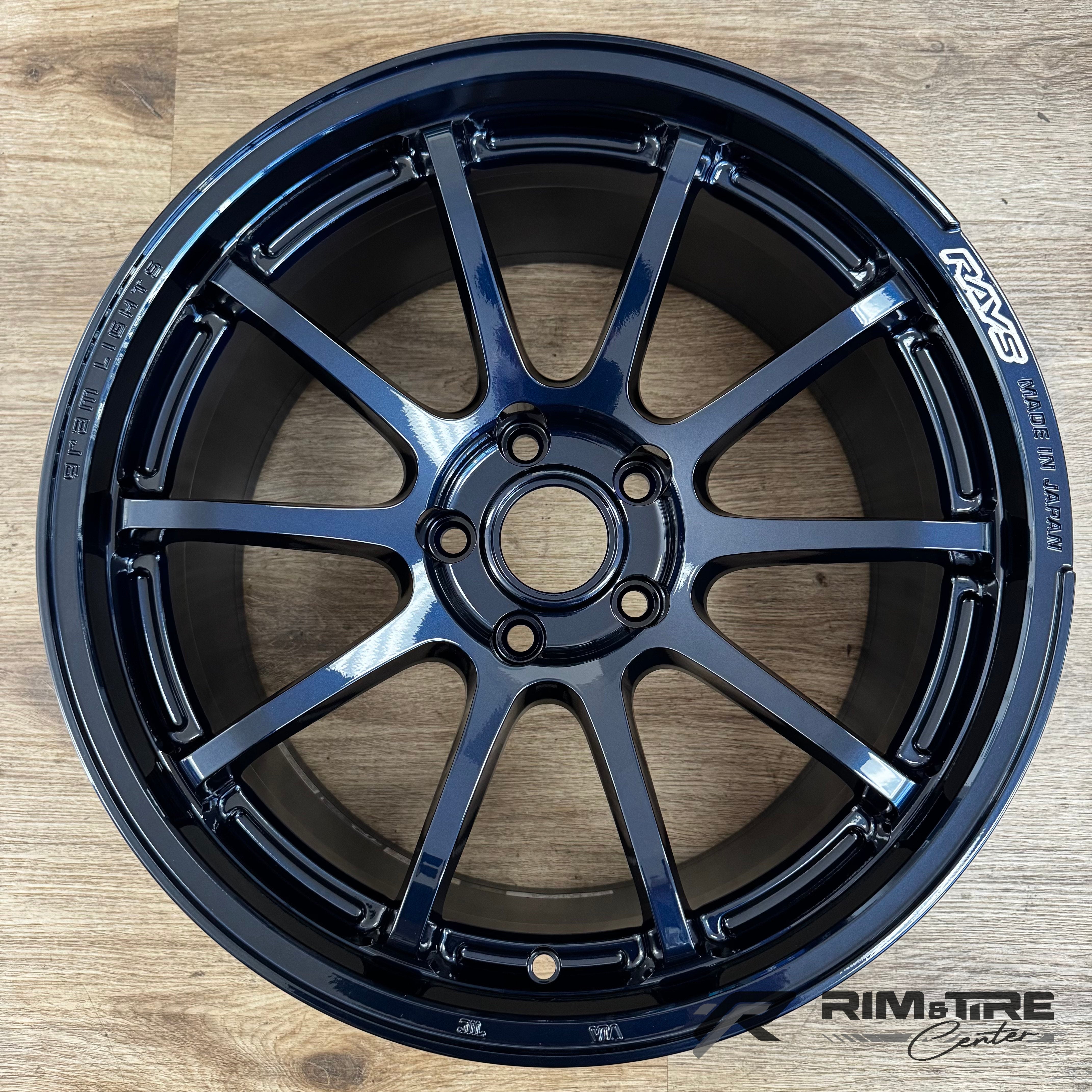 RAYS Volk Racing ZE40 ten-spoke wheel in a glossy Burning Blue Black finish Made in Japan displayed on a light wooden floor