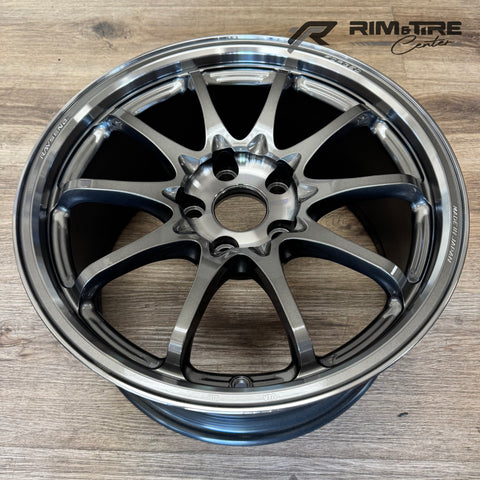 RAYS ENGINEERING forged gunmetal gray 10-spoke automotive wheel with a polished lip and Made in Japan inscription on a light wood floor