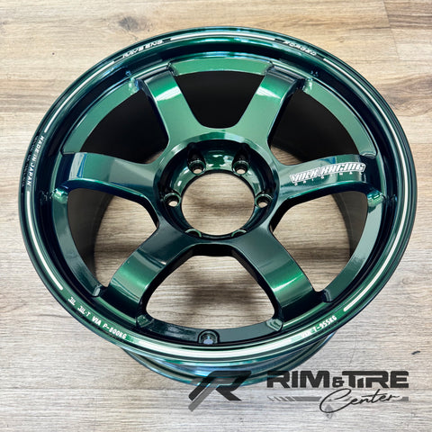 Forged RAYS Volk Racing TE37 alloy wheel in a glossy emerald green finish featuring a five-spoke design with white RAYS ENG, VOLK RACING ORIGINAL, FORGED, and MADE IN JAPAN text on a light wooden floor