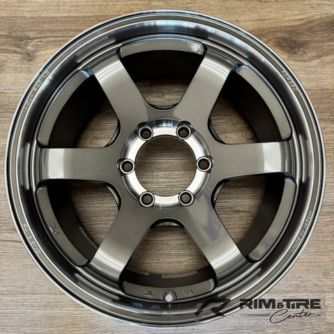 Product photo of a Volk Racing TE37 SL forged wheel in gunmetal gray with a 6-spoke design on a light wooden floor