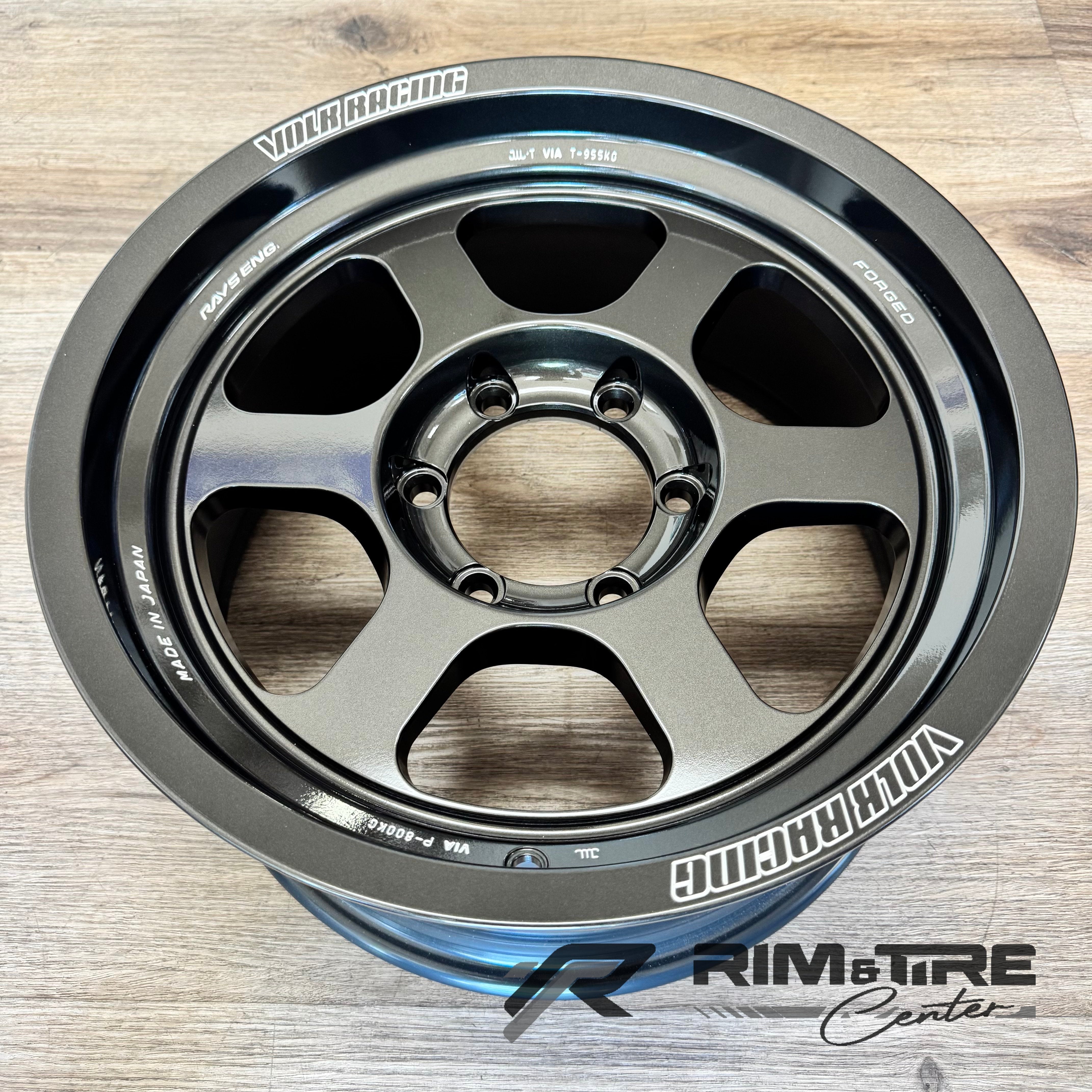 Volk Racing RAYS Engineering forged TE37 alloy wheel in matte gunmetal finish featuring an iconic six-spoke design and 'MADE IN JAPAN' text on a light wood floor